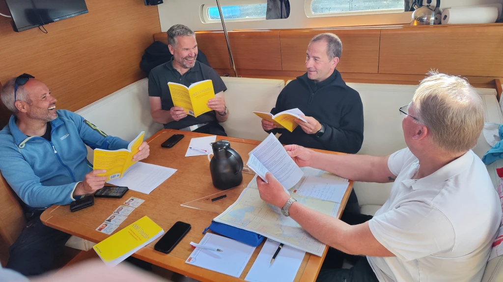 An Bord bei einem SSS Törn. Alle arbeiten intensiv mit dem SSS Praxis Buch